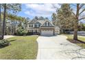 Beautiful two-story home with well-kept lawn, large driveway and lush landscaping, set amongst mature trees at 1033 Jensen Grove Ct, Fuquay Varina, NC 27526