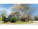 Two story gray house on a corner lot with mature trees and a landscaped yard at 105 Cherry Grove Dr, Cary, NC 27519