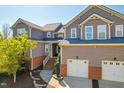 Charming townhome featuring brick accents, a two-car garage, and inviting front porch at 11003 Louson Pl, Raleigh, NC 27614
