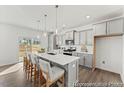 Modern kitchen boasts a spacious island with seating, stylish pendant lights, and stainless steel appliances at 111 Silver Moon Ln # 121, Clayton, NC 27527