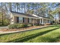 A well-maintained ranch home with a brick facade, dark shutters, and manicured landscaping at 11801 Strickland Rd, Raleigh, NC 27613