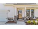 Close-up of the front entrance boasting a welcoming porch, stylish stone accents, and seating area at 1408 Weavers Trace Dr, Zebulon, NC 27597