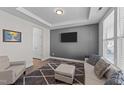 Comfortable living room showcasing tray ceilings, a TV, modern furniture, and neutral decor at 1408 Weavers Trace Dr, Zebulon, NC 27597
