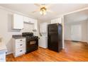 Cozy kitchen features white cabinetry, black appliances, and hardwood floors at 164 Torain St, Hillsborough, NC 27278