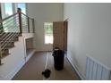 Bright entryway featuring a staircase with metal railing and light wood trim, and a door with horizontal wood panels at 170 Cherry Bark Dr, Youngsville, NC 27596