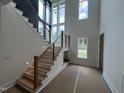 Grand entryway featuring a staircase with metal accents, large windows, and modern lighting at 170 Cherry Bark Dr, Youngsville, NC 27596