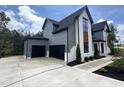 Modern home featuring a three-car garage, landscaped yard, and stylish exterior at 170 Cherry Bark Dr, Youngsville, NC 27596