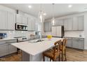 Modern kitchen with gray cabinets, stainless steel appliances, and a quartz countertop island at 190 Salem Village Dr, Fuquay Varina, NC 27526