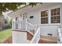 A close up of the white front door with glass panes and brick stairs leading to the front entrance at 1921 Clark Ave # 105, Raleigh, NC 27605