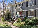 Charming two-story home with gray siding, black shutters, front porch, and landscaped yard at 2005 Bridgeport Dr, Raleigh, NC 27615