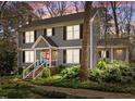 Charming two-story home with gray siding, black shutters, front porch, and landscaped yard at 2005 Bridgeport Dr, Raleigh, NC 27615