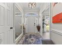 Elegant entryway features a large mirror, stylish rug, chandelier, and white wainscoting at 209 Ashmore Ln, Rocky Mount, NC 27804