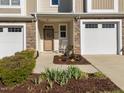 Inviting front porch with stone details, a white rocking chair, and a lovely garden bed at 2523 Spring Oaks Way, Raleigh, NC 27614
