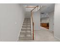 Carpeted staircase with white and wood railing leading to the upper level and a glimpse of the kitchen at 2523 Spring Oaks Way, Raleigh, NC 27614