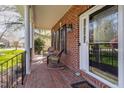 Covered front porch with comfortable seating, brick flooring, and a decorative glass front door at 2900 London Bell Dr, Raleigh, NC 27614