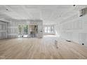 Spacious living room with hardwood floors, sliding glass doors and drywall in progress at 2957 Wexford Pond Way, Wake Forest, NC 27587