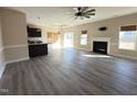 Spacious living room featuring a fireplace, modern ceiling fan, and seamless flow into the kitchen at 30 Wheat Dr, Angier, NC 27501