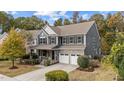 Two-story home with a stone and siding exterior, a well-manicured lawn, and a two-car garage at 3409 Lily Orchard Way, Apex, NC 27539