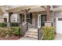 Inviting front porch with stone accents, wooden supports, and well-maintained landscaping at 3409 Lily Orchard Way, Apex, NC 27539