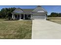 Charming single-Gathering home featuring a well-manicured lawn, long driveway, and attached two-car garage at 4013 Kingcraig Ln, Zebulon, NC 27597