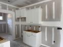 View of the bright kitchen featuring white cabinets, ready for final touches and appliances at 4013 Kingcraig Ln, Zebulon, NC 27597