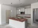 Bright kitchen featuring white cabinets, a stainless steel microwave, and an island with a sink at 4013 Kingcraig Ln, Zebulon, NC 27597