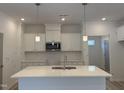Stylish kitchen features a quartz-topped island, white cabinetry, stainless microwave, and modern pendant lighting at 4013 Kingcraig Ln, Zebulon, NC 27597