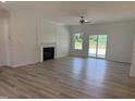 Bright living room with fireplace, ceiling fan, wood-look flooring, and sliding door access to the outdoors at 4013 Kingcraig Ln, Zebulon, NC 27597