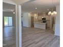 Open-concept living space with light wood floors, recessed lighting, and views into the kitchen and outdoor patio at 4013 Kingcraig Ln, Zebulon, NC 27597