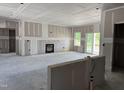 An expansive living room features large windows, a cozy fireplace, and potential for customization at 4013 Kingcraig Ln, Zebulon, NC 27597