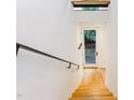 Bright stairwell with light hardwood floors and a contemporary steel handrail at 402 Chavis Way, Raleigh, NC 27601