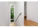 Bright stairwell with light hardwood floors and a contemporary steel handrail at 402 Chavis Way, Raleigh, NC 27601
