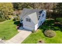 Aerial view of a bright home with a large lawn, mature trees and an attached two-car garage at 4108 4108 Gallatree Ln, Raleigh, NC 27616