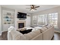 Inviting living room featuring a fireplace, built-in shelving, and a plush white sofa at 4619 Paces Ferry Dr, Durham, NC 27712