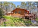 A full backyard view shows home with a wooden deck and stairs to wooded backyard at 501 Hiddenbrook Dr, Durham, NC 27703