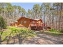 Rear exterior showcasing home with a deck and steps leading to the wooded yard at 501 Hiddenbrook Dr, Durham, NC 27703