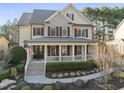 Lovely two-story home boasting a charming covered front porch, American flag, and manicured landscaping at 512 Hallburg Ct, Wake Forest, NC 27587
