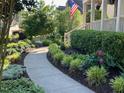 A winding walkway leads to a home's entrance, surrounded by lush greenery and landscape lighting at 512 Hallburg Ct, Wake Forest, NC 27587