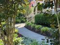 A winding walkway leads to a home's entrance, surrounded by lush greenery and landscape lighting at 512 Hallburg Ct, Wake Forest, NC 27587