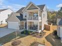 Inviting two-story home boasts a charming front porch, perfect for relaxing outdoors, complemented by a well-manicured lawn at 524 Glenwyck Ct, Fuquay Varina, NC 27526