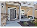 Welcoming front porch with stone accents, comfortable seating, and a well-maintained entrance, creating an inviting first impression at 524 Glenwyck Ct, Fuquay Varina, NC 27526