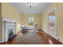 Bright living room featuring hardwood floors, a fireplace, and rocking chairs by a window at 529 Hillcrest Ave, Burlington, NC 27215