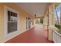 Spacious front porch with painted wood flooring, decorative columns, and charming exterior lighting at 529 Hillcrest Ave, Burlington, NC 27215