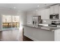 Open kitchen boasts granite counters, stainless appliances, and sliding doors to the deck at 5320 River Reach Dr, Raleigh, NC 27616