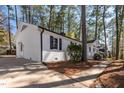 Side view of a white brick home with black accents and a well-manicured lawn at 5812 Timber Ridge Dr, Raleigh, NC 27609