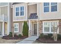 Close up of a townhome featuring stone accents and professional landscaping with a walkway to the front door at 590 Grand Central Sta, Apex, NC 27502