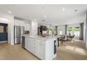 Open-concept kitchen with quartz countertops, stainless appliances, and a view of the living area at 6019 Enclosure Way, Durham, NC 27703