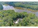 Aerial view of a home nestled amongst lush trees on a property with lake frontage at 6452 Therfield Dr, Raleigh, NC 27614