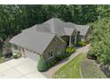 Aerial view of a brick home featuring an attached garage, manicured lawn, and a paved driveway at 6452 Therfield Dr, Raleigh, NC 27614