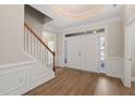 Bright foyer with hardwood floors, staircase, and a double door entrance at 7652 Channery Way, Raleigh, NC 27616